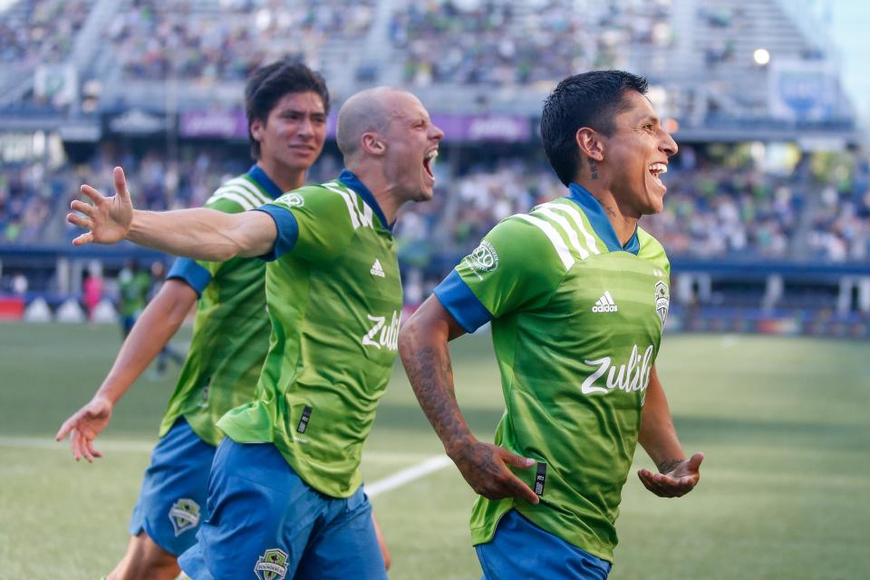 Raul Ruidiaz (right) celebrates with Seattle Sounders teammates Josh Atencio and Brad Smith after scoring a goal against the Vancouver Whitecaps FC at Lumen Field.
