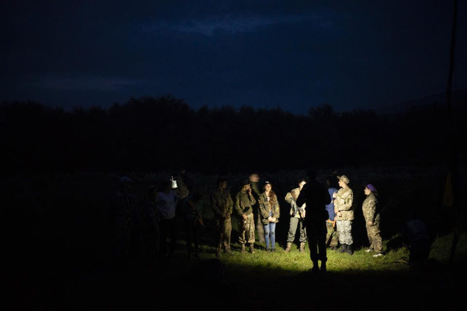 In this July 28, 2018 photo, young participants of the "Temper of will" summer camp, organized by the nationalist Svoboda party, receive instructions in a village near Ternopil, Ukraine. The camp has two purposes: to train children to defend their country _ and to spread nationalist ideology. (AP Photo/Felipe Dana)