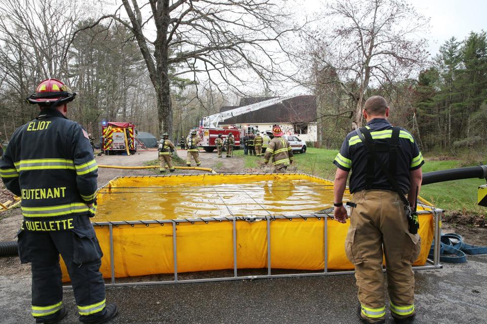 A portable water tank is used by firefighters battling a blaze on Witchtrot Road in South Berwick, Maine, Tuesday, May 2, 2023.