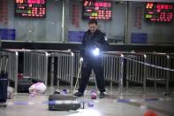 A police investigator inspects the scene of a mass stabbing at the railway station in Kunming, southwest China's Yunnan province, on March 2, 2014