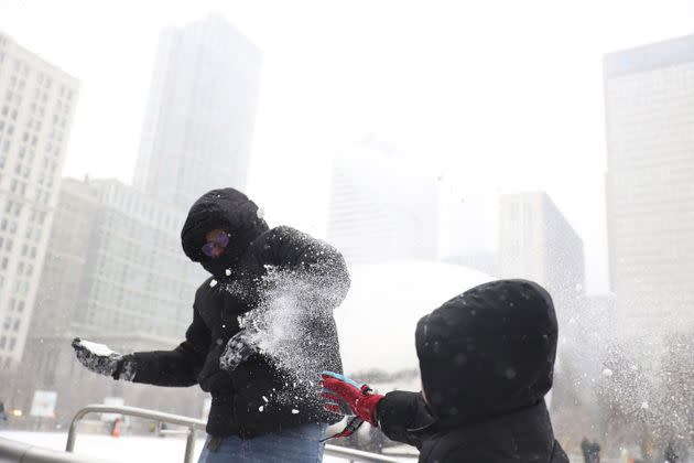 Andres Garduno and his son Matteo Jimenez Garduno, both from Mexico, have a snowball fight during the winter storm at Chicago's Millennium Park ice rink on Thursday.