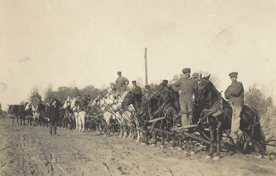 A crew poses for a photo during installation of a road in Bedford Township during the early 20th century. Part of road building included the installation of side drainage ditches, which were critical to ensuring that the water could drain away from the road to maintain the structure of the roadway.