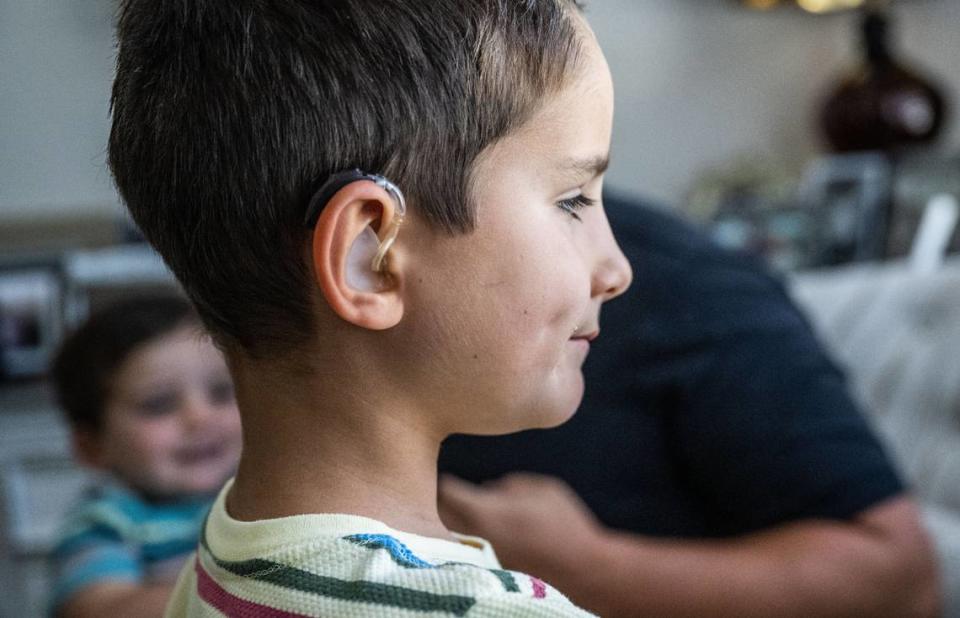 Jake Janes, 6, looks out the window at his home on July 28 as he wears his hearing aid.