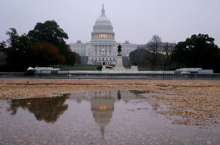 The U.S. Capitol building is seen reflected in a puddle at sunrise on the day of the U.S. midterm election as voters go to the polls across the country to elect 33 U.S. senators and all 435 members of the U.S. House of Representatives in Washington, U.S., November 6, 2018. REUTERS/Jim Bourg
