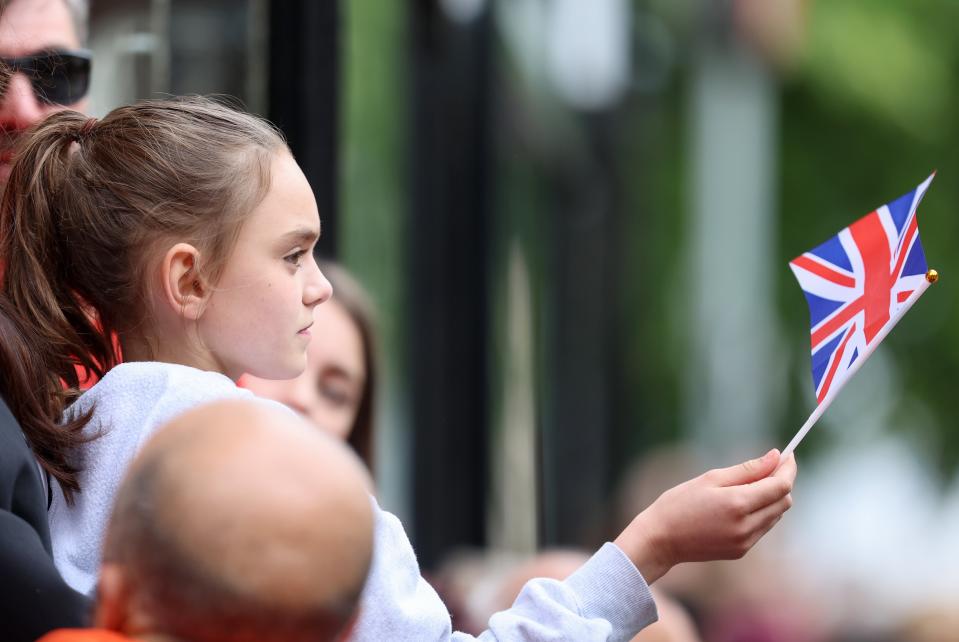 A girl waves a Union Jack flag as she stands outside the cathedral (Getty Images)