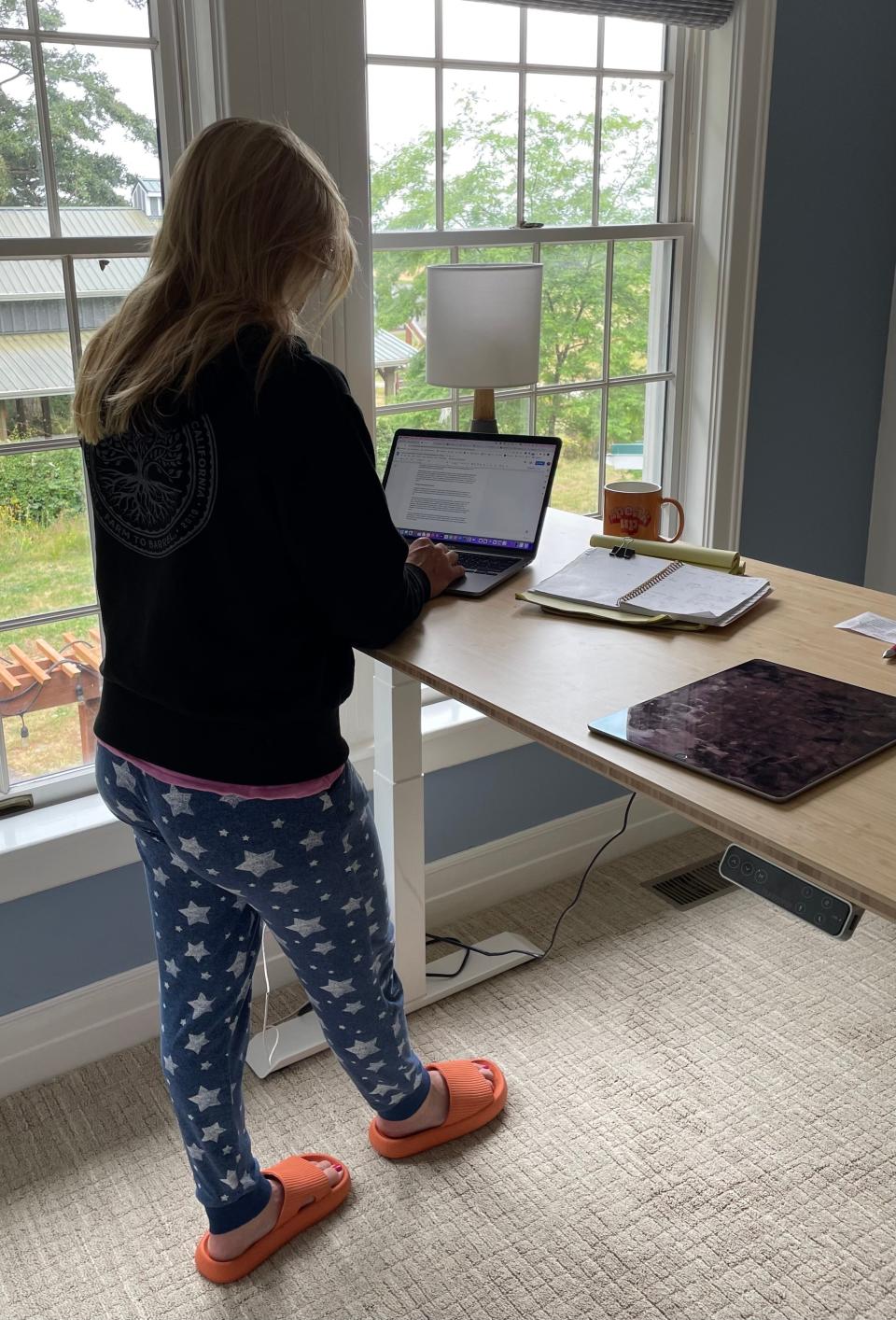 Jolly turned a spare bedroom into her dedicated workspace and types away at a standing desk.