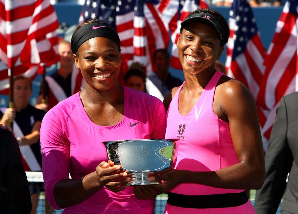 Serena Williams, left, and Venus Williams pose with the championship trophy from the women's doubles final at the U.S. Open on Sept. 14, 2009.