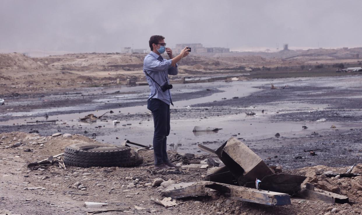 Matt Willingham of PLC stands at the Qayyarah check point where burning oil still consumes the area. (Photo: Ash Gallagher for Yahoo News)