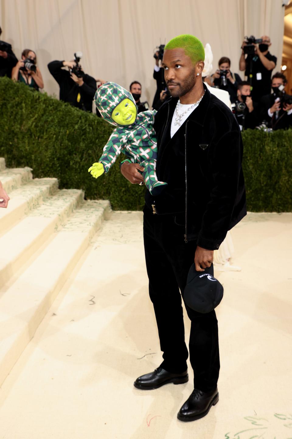 Why did Frank Ocean bring a neon green baby robot to the 2021 Met Gala? The moving, blinking, and animatronic doll was inspired by, in Frank's words, “movie magic” and “America.” Alrighty, then!