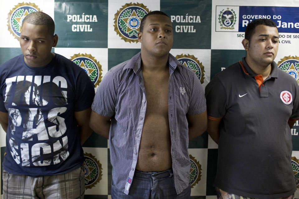 Suspects Wallace Aparecido Souza Silva, left, Carlos Armando Costa dos Santos, center, and Jonathan Foudakis de Souza are presented to the press at the Special Police Unit for Tourism Support (DEAT) after being arrested for allegedly attacking tourists in Rio de Janeiro, Brazil, Tuesday, April 2, 2013. An American woman was gang raped and beaten aboard a public transport van while her French boyfriend was shackled, hit with a crowbar and forced to watch the attacks after the pair boarded the vehicle in Rio de Janeiro's showcase Copacabana beach neighborhood, police said. The attacks took place over six hours starting shortly after midnight on Saturday. (AP Photo/Felipe Dana)