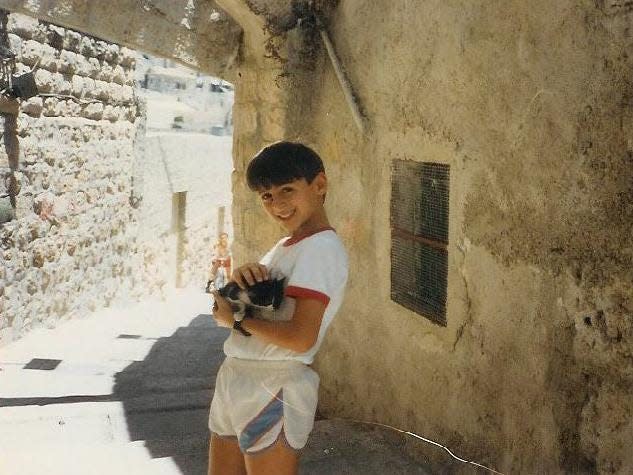 Rami Kashou as a 12 year old in Jerusalem holding a cat