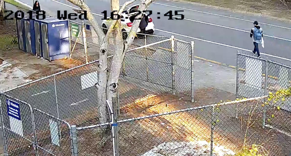 The owner of the car can be seen removing clothes from the boot as the thief makes his way down the footpath. Source: Queensland Police