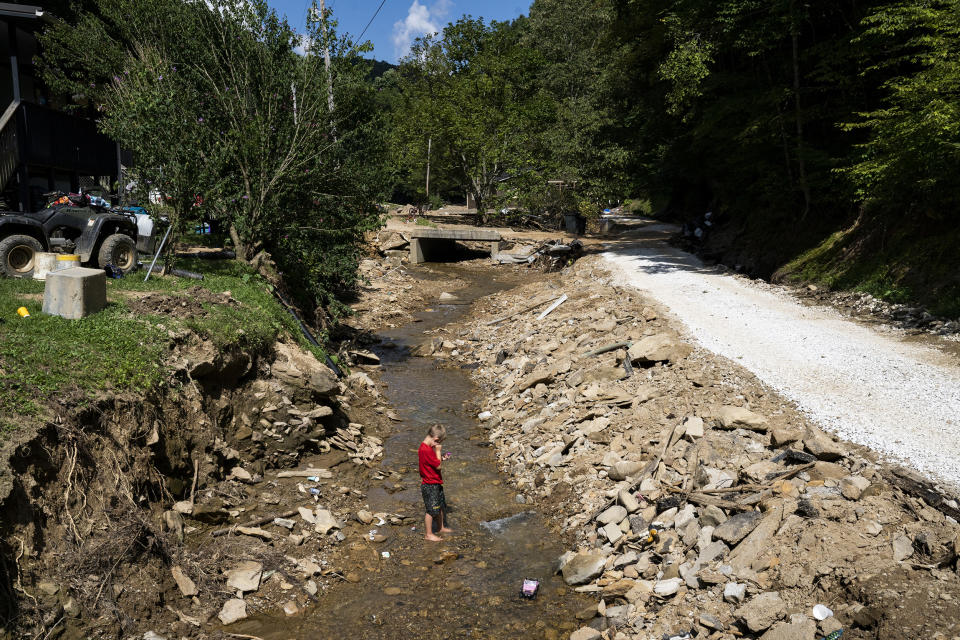 Image: Hazen White, 7, plays in the creek that flooded the River Caney community of Lost Creek on August 18, 2022. (Michael Swensen for NBC News)