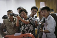 <p>North Koreans play shooting games in an arcade at the Kaeson Youth Amusement Park, Sept. 3, 2014 in Pyongyang, North Korea. (Photo: Wong Maye-E/AP) </p>