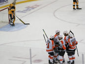 Philadelphia Flyers' Sean Couturier (14) celebrates with teammates after scoring against Pittsburgh Penguins goaltender Tristan Jarry (35) during the first period of an NHL hockey game Thursday, March 4, 2021, in Pittsburgh. (AP Photo/Keith Srakocic)