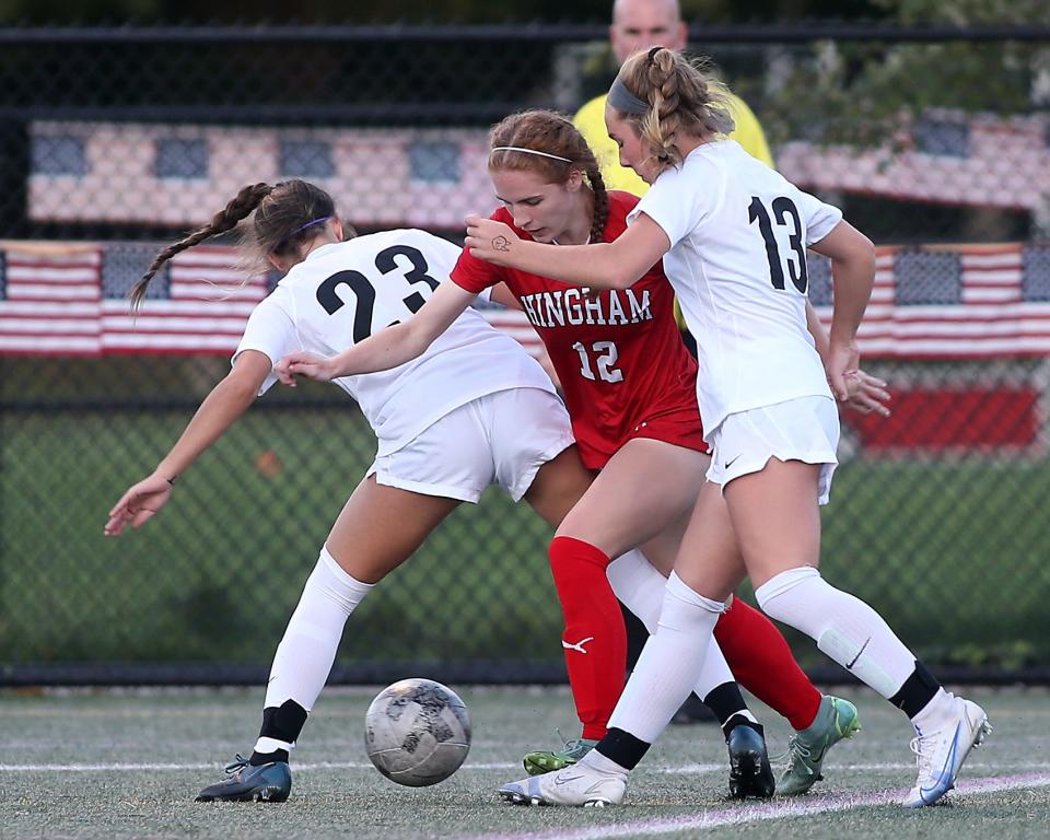 Hingham's Claire Murray tries to squeeze through Whitman-Hanson's Savannah Kamperides and Whitman-Hanson's Alexis Cole during first half action of their game against Whitman-Hanson at Hingham High on Tuesday, Sept. 27, 2022. 