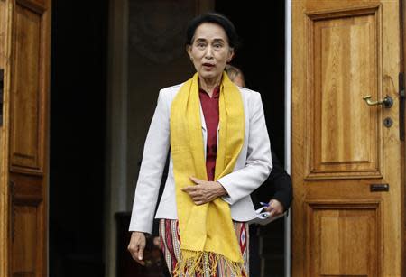 Myanmar's opposition leader Aung San Suu Kyi reacts after seeing photographers waiting for her after her meeting with Poland's former president Lech Walesa (not pictured) at Myslewicki Palace in Warsaw September 12, 2013. REUTERS/Kacper Pempel