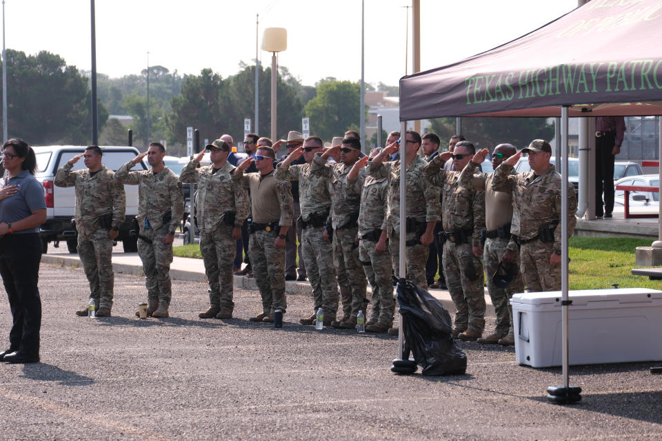 DPS tactical officers salute at a boat dedication ceremony for Trooper Matthew Myrick Friday morning at the Texas Panhandle War Memorial Center in Amarillo.