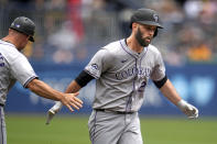 Colorado Rockies' Jacob Stallings, right, is greeted by third base coach/infield coach Warren Schaeffer, left, as he rounds third after hitting a two-run home run off Pittsburgh Pirates starting pitcher Bailey Falter during the second inning of a baseball game in Pittsburgh, Sunday, May 5, 2024. (AP Photo/Gene J. Puskar)
