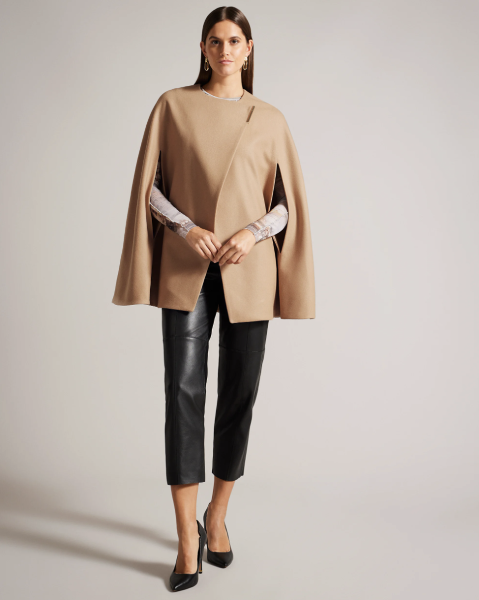 model in black heels, leather pants and Valariy Melton Wool Cape in Camel (Photo via Ted Baker)