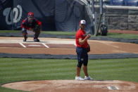 Washington Nationals' pitcher Tanner Rainey, foreground, pauses on the mound during a baseball training camp workout at Nationals Stadium, Sunday, July 5, 2020, in Washington. (AP Photo/Carolyn Kaster)