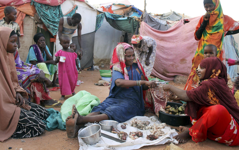 In this photo taken Thursday, Sept. 20, 2012, women displaced from the capital Mogadishu chop meat to sell to customers in the once-bustling pirate town of Galkayo, Somalia. The empty whisky bottles and overturned, sand-filled skiffs that litter this shoreline are signs that the heyday of Somali piracy may be over - most of the prostitutes are gone, the luxury cars repossessed, and pirates talk more about catching lobsters than seizing cargo ships. (AP Photo/Farah Abdi Warsameh)