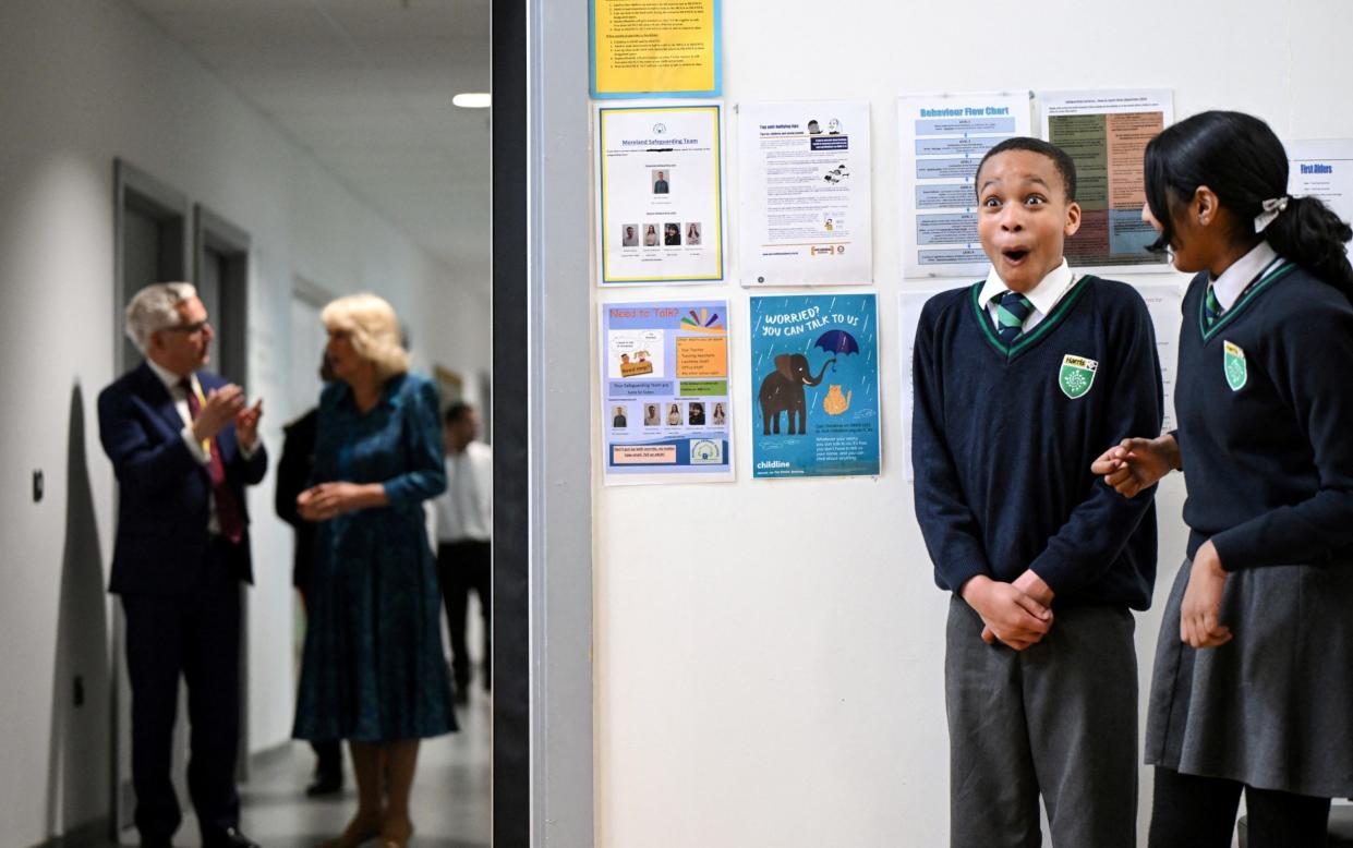 Schoolchildren cannot hide their excitement as they wait for the Queen