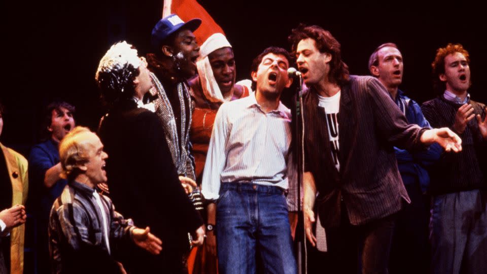 "Do They Know It's Christmas?" quickly became a highly spoofed single. Here, Nigel Planer, Graham Chapman, Bob Geldof, Frank Bruno, Lenny Henry, Ben Elton, Christopher Ryan (back), David Rappaport and Dawn French sing a version for a comedy show in April 1986. - Comic Relief/Getty Images