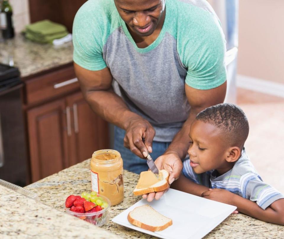 Father making his son a peanut-butter-and-jelly sandwich | Getty