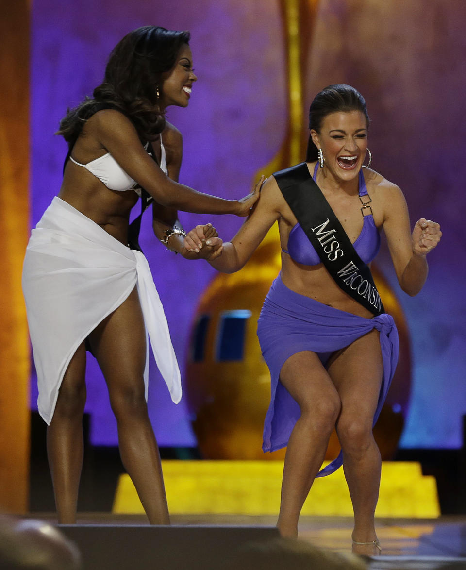 Miss Wisconsin Paula Mae Kuiper, right, reacts after finding out she's advancing beyond the lifestyle round as Miss Texas Ivana Hall congratulates her during the Miss America 2014 pageant, Sunday, Sept. 15, 2013, in Atlantic City, N.J. (AP Photo/Mel Evans)