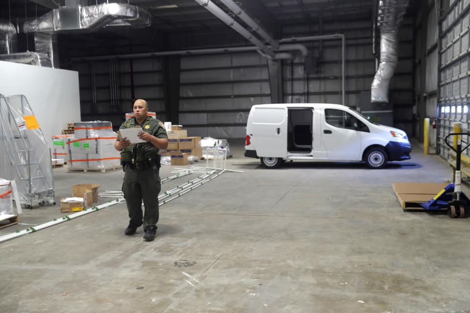 An East baton Rouge Sheriff deputy supervises the loading of the first ever shipment of medical marijuana in the state of Louisiana, at GB Sciences Louisiana, in Baton Rouge, La., Tuesday, Aug. 6, 2019. (AP Photo/Gerald Herbert)