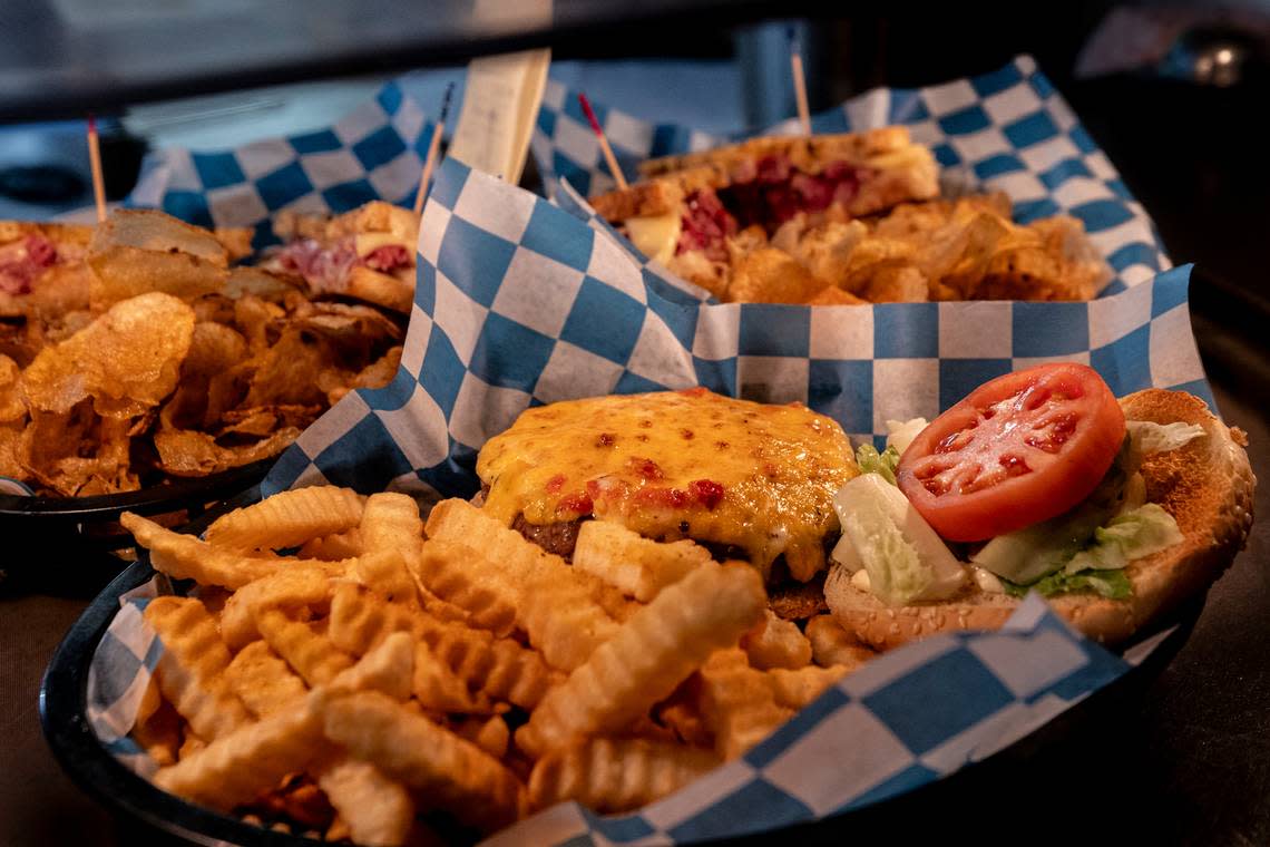 Lunch offerings from Publick House including a pimento cheeseburger, in front and house made corned beef.