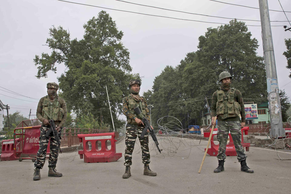 Indian paramilitary soldiers stand guard near a temporary check post on the road leading towards Independence Day parade venue during lockdown in Srinagar, Indian controlled Kashmir, Thursday, Aug. 15, 2019. Indian Prime Minister Narendra Modi says that stripping the disputed Kashmir region of its statehood and special constitutional provisions has helped unify the country. Modi gave the annual Independence Day address from the historic Red Fort in New Delhi as an unprecedented security lockdown kept people in Indian-administered Kashmir indoors for an eleventh day. (AP Photo/ Dar Yasin)