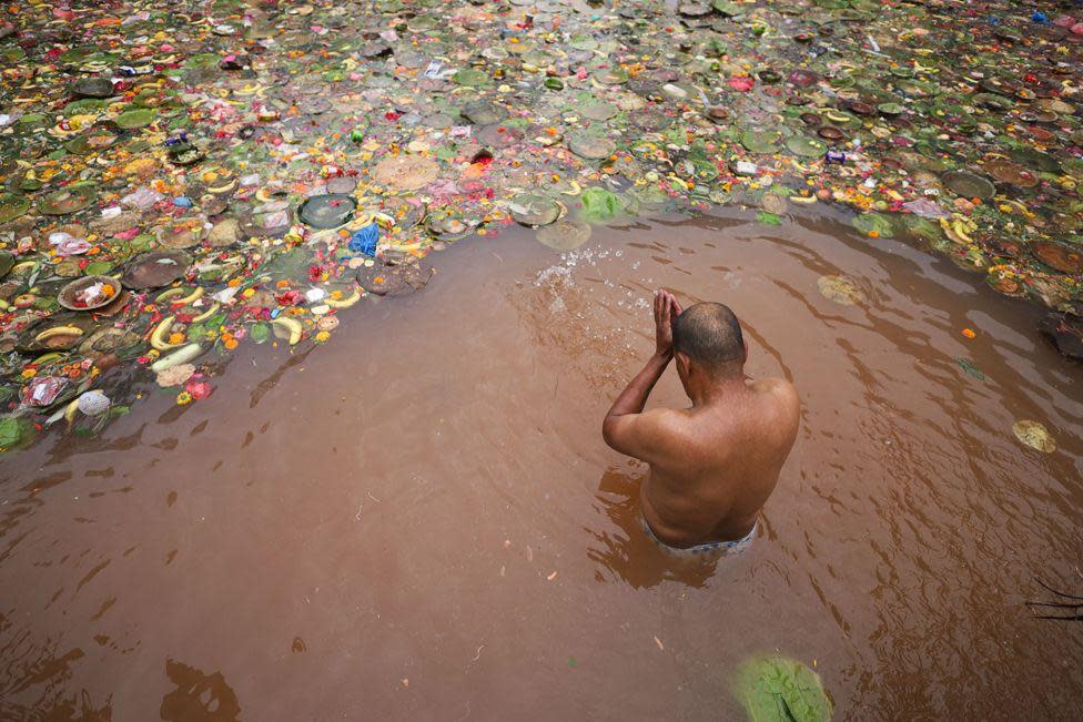 A Nepali Hindu is taking a bath in a sacred pond, Matatirtha, on the outskirts of Kathmandu, Nepal