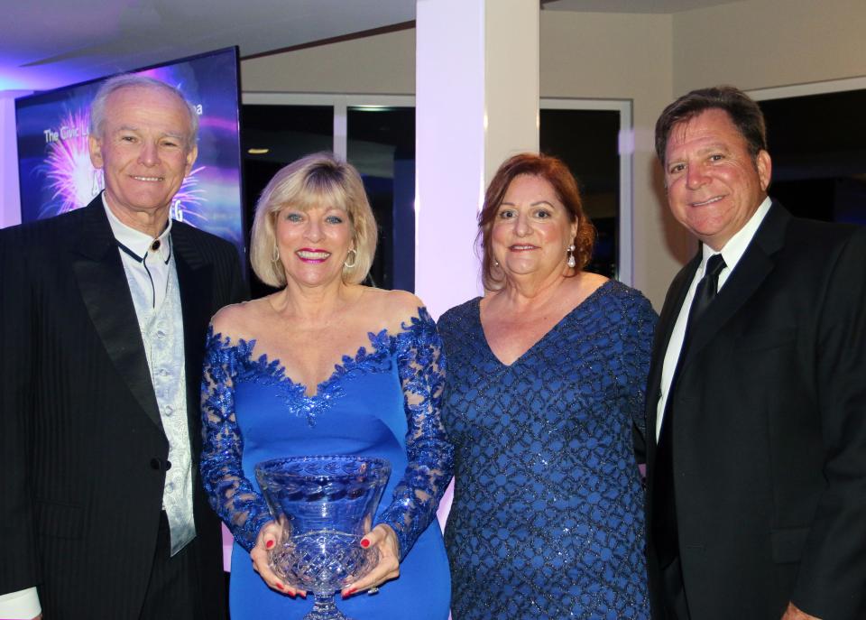 Nancy Lohman holds the J. Saxton Lloyd Distinguished Community Service Award for 2020 that she and her husband Lowell, left, received at the Civic League of the Halifax Area's annual dinner meeting at Oceanside Country Club in Ormond Beach on March 4, 2022. Also pictured: Mary Greenlees, Civic League chair from 2019-2021, and Civic League member Bobby Thigpen who presented the award. This was the Civic League's first annual dinner since the start of the COVID-19 pandemic in 2020.