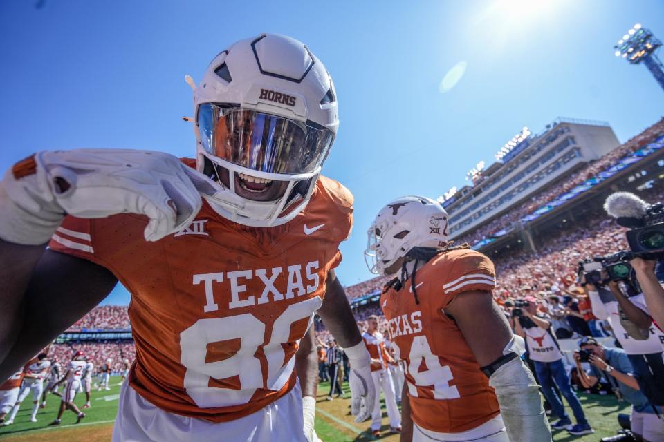 Texas offensive lineman Malik Agbo, left, who often serves as a blocking tight end, celebrates a Longhorns touchdown against Oklahoma Saturday at the Cotton Bowl in Dallas. Oklahoma rallied for a 34-30 win, but Texas still has realistic hopes of playing for the Big 12 title.