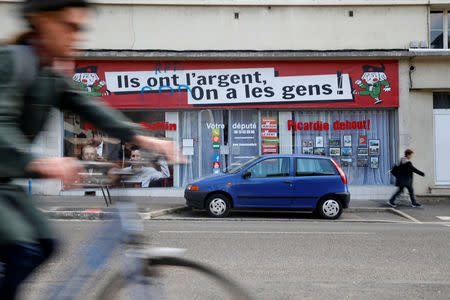 A cyclist rides past the local headquarters of Francois Ruffin, a member of parliament of political party " La France Insoumise" (France Unbowed), in Amiens, France, May 16, 2019. REUTERS/Pascal Rossignol