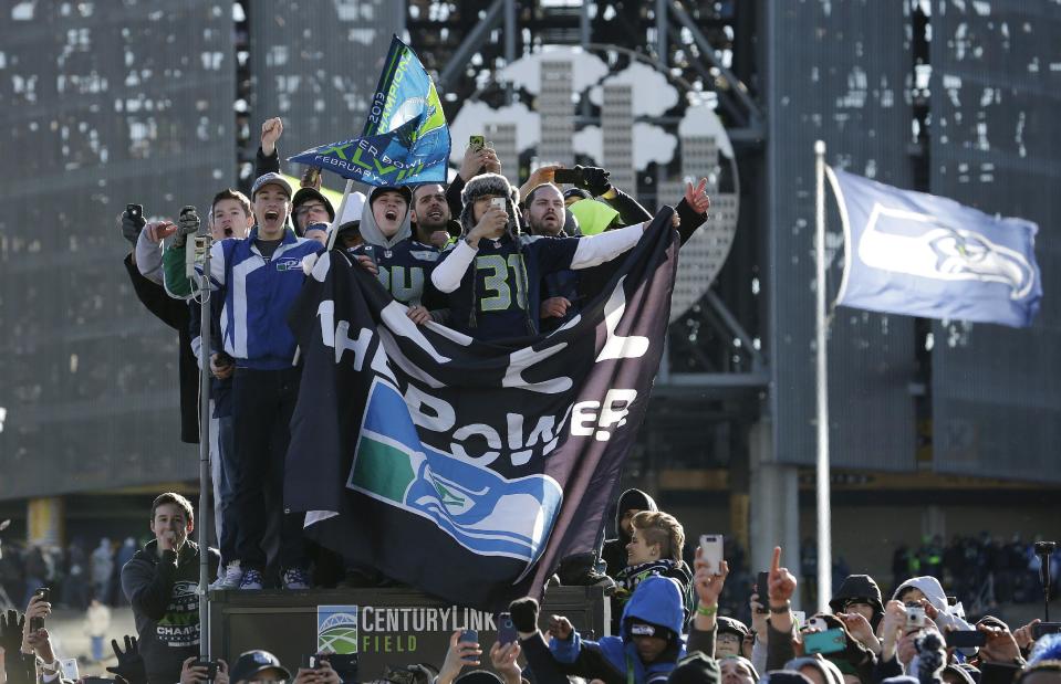 Seattle Seahawks fans cheer during the parade for the NFL football Super Bowl champions, Wednesday, Feb. 5, 2014, in Seattle. The Seahawks defeated the Denver Broncos 43-8 in Super Bowl XLVIII on Sunday. (AP Photo/Elaine Thompson)