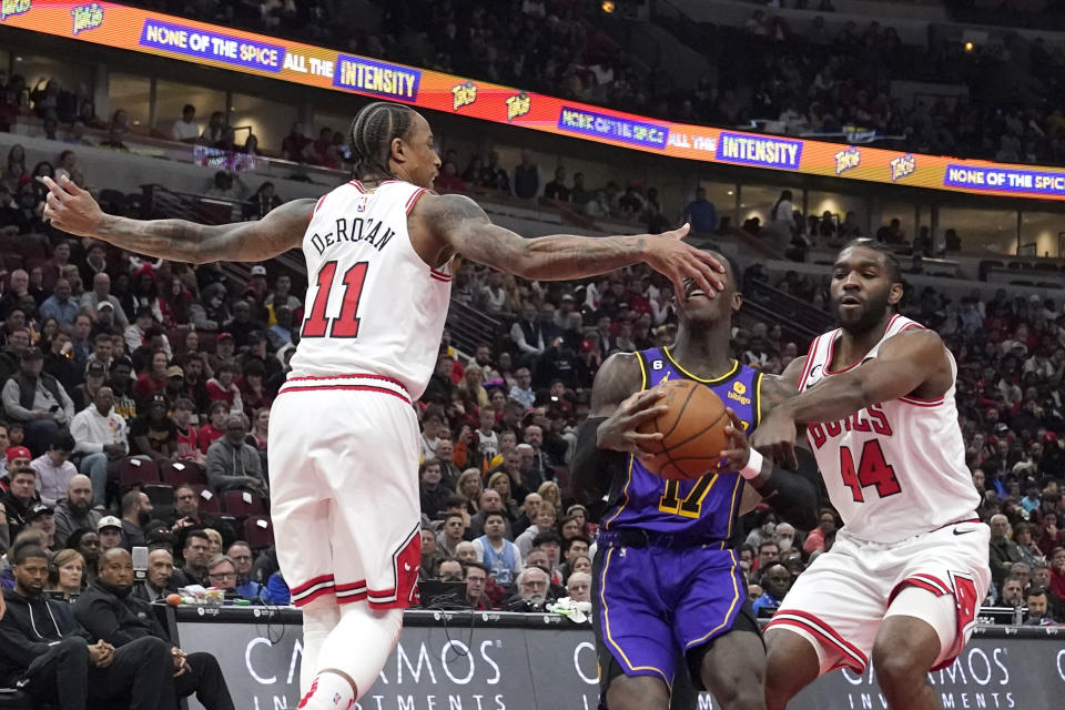 Los Angeles Lakers' Dennis Schroder drives to the basket as Chicago Bulls' DeMar DeRozan hits his face and Patrick Williams is called for a foul during the first half of an NBA basketball game, Wednesday, March 29, 2023, in Chicago. (AP Photo/Charles Rex Arbogast)