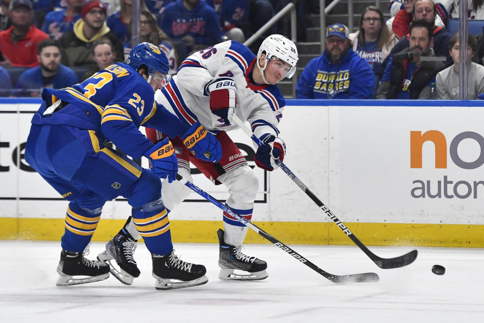 New York Rangers left wing Jimmy Vesey, right, shoots on goal while pressured by Buffalo Sabres defenseman Mattias Samuelsson during the first period of an NHL hockey game in Buffalo, N.Y., Friday, March 31, 2023. (AP Photo/Adrian Kraus)