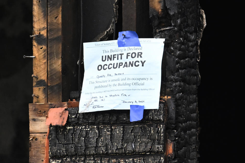 A sign is posted in the aftermath of a fire in two-family home in Somers, Conn., Wednesday, Jan. 3, 2024. Four children died Tuesday night in a fire that broke out in the home. The children, ages 5, 6, 8 and 12, were found inside the house where 11 people lived, fire and town officials said. (AP Photo/Jessica Hill)