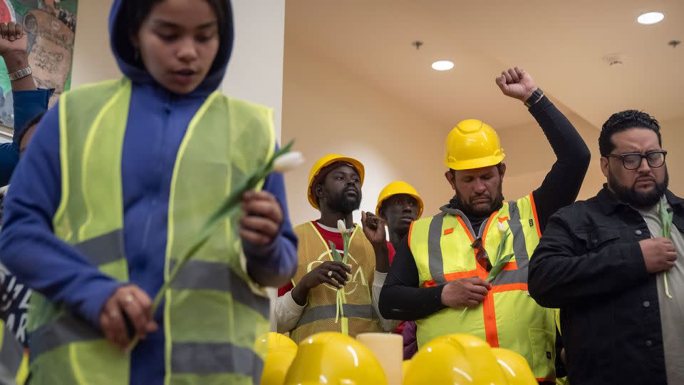 Construction workers and supporters reflect during a moment of prayer at a vigil and news conference by CASA of Maryland on Friday in Baltimore. - Mark Schiefelbein/AP