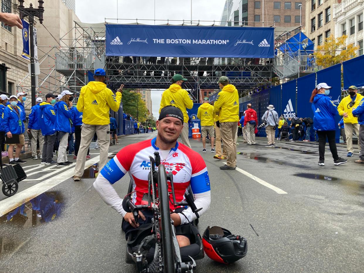 Zach Stinson, of Chambersburg, Pa., reacts after crossing the finish line in first place in the handcycle division at the 2021 Boston Marathon.