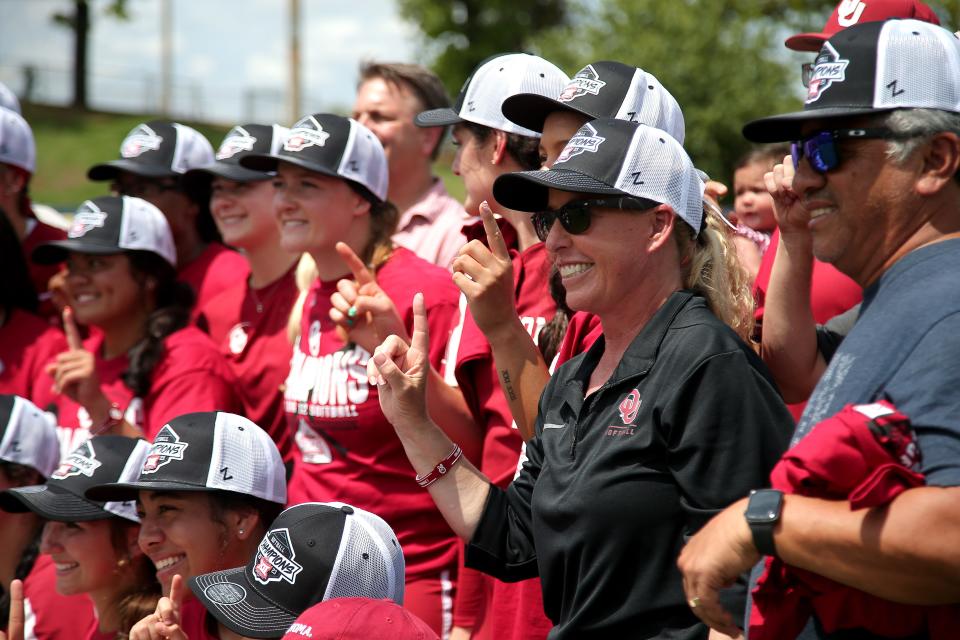 Oklahoma coach Patty Gasso poses for a photo with her team after winning the Big 12 softball tournament championship game between the University of Oklahoma Sooners (OU) and the Texas Longhorns at USA Softball Hall of Fame Stadium in Oklahoma City, Saturday, May 13, 2023. Oklahoma won 6-1.