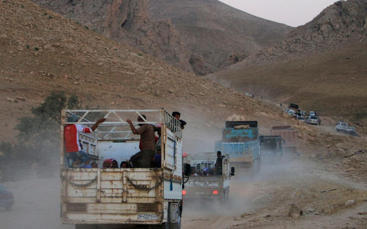 Displaced people from the Yazidi religious minority, fleeing violence from forces loyal to the Islamic State in Sinjar town, ride trucks as they are evacuated - Reuters