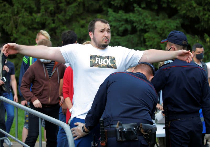 Police officers perform a body search on a man before an election campaign rally of presidential candidate Svetlana Tikhanouskaya in Minsk