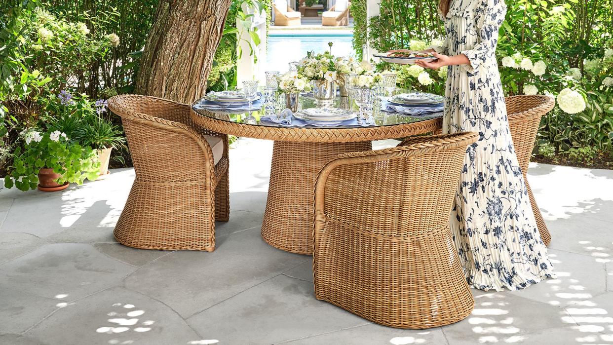 a person standing next to a table with baskets and plants