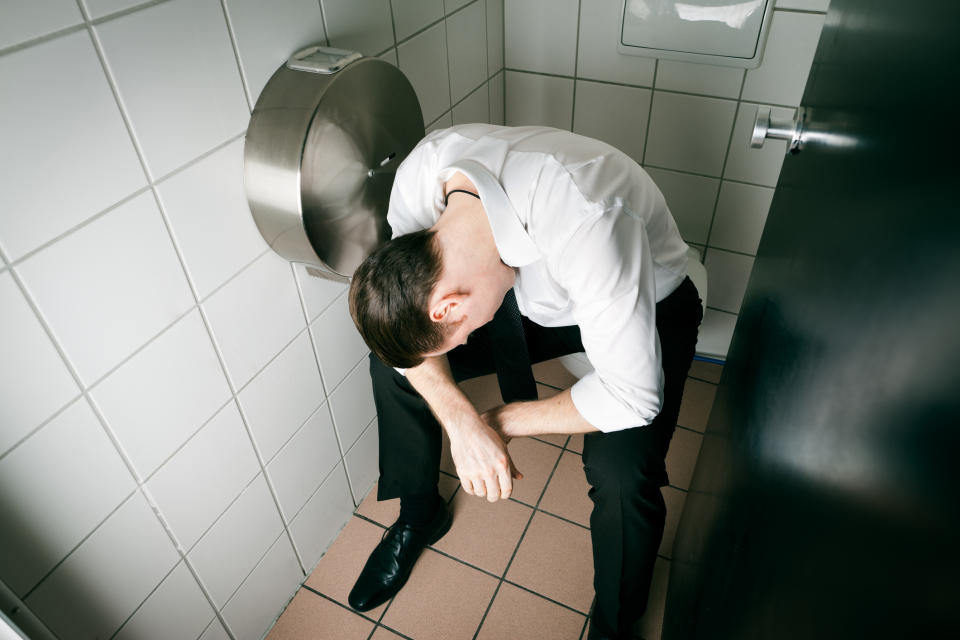 guy passed out on fully clothed on the toilet