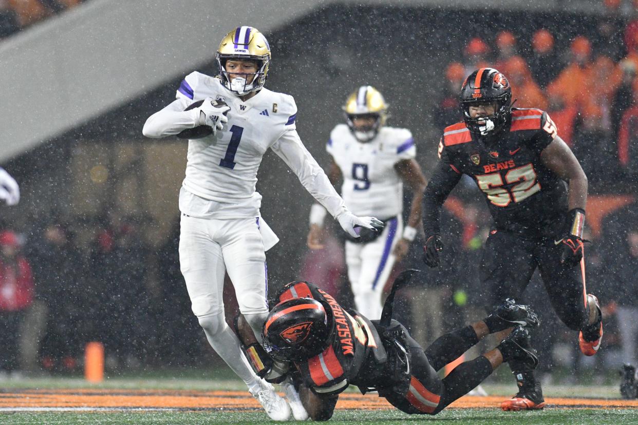 Washington wide receiver Rome Odunze (1) is brought down by Oregon State linebacker Easton Mascarenas-Arnold (5) during the first half of the game on Nov. 18 in Corvallis.