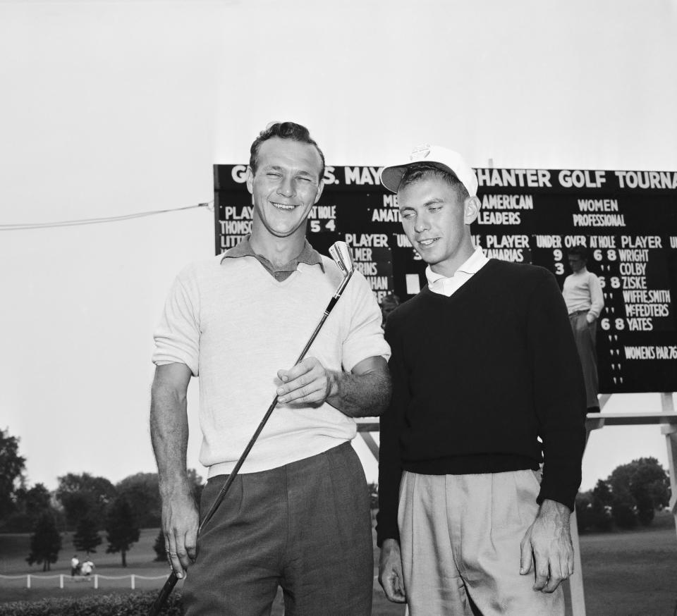 FILE - Arnold Palmer, left, 24, of Cleveland, Ohio, holds a 2-iron and talks with Eddie Merrins of Meridan, Miss., after Palmer won the All-American amateur golf tournament, Aug. 8, 1954, at Chicago's Tam O'Shanter club. Merrins was runner-up. Merrins, the famous teach pro in Los Angeles, died Wednesday, Nov. 22, 2023 at age 91. (AP Photo/Edward Kitch, File)